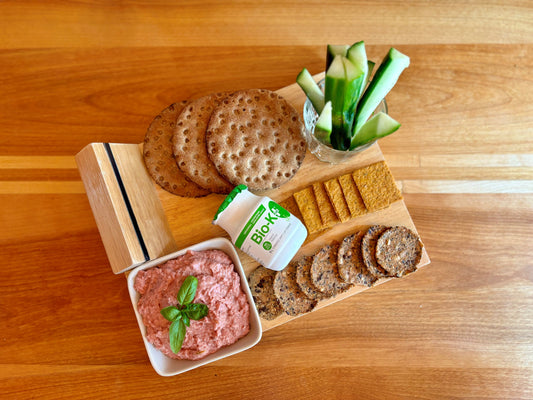 Plate of crackers with a Bio-K+ bottles and a healthy hummus