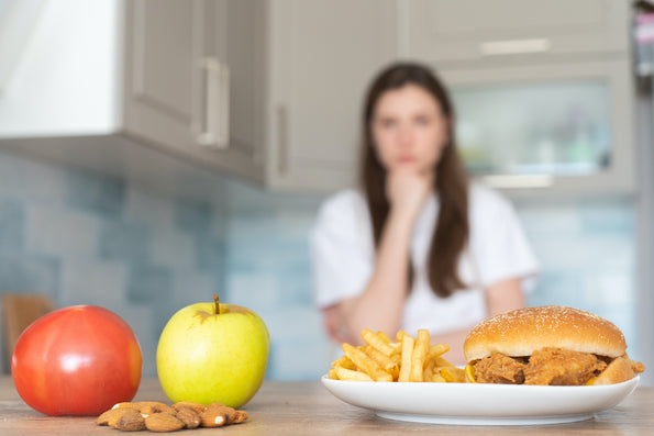 Burger with on the side an apple and a tomato